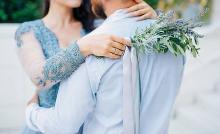 Lavender Wedding bouquet in hands of the bride in white-blue dressの写真素材