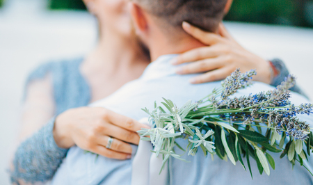 Lavender Wedding bouquet in hands of the bride in white-blue dressの写真素材
