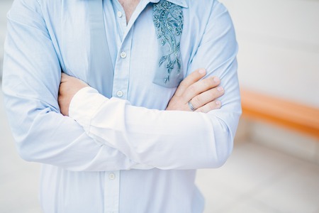 Male hands crossed on chest. Hands of the groom on the chest.の写真素材