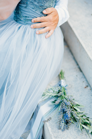 Lavender Wedding bouquet lies on the stairs next to the bride and groomの写真素材