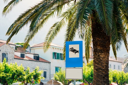 Road sign Hotel or motel. In the street under a palm treeの写真素材