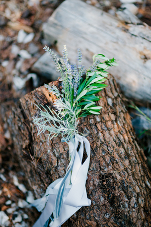 Wedding bouquet with lavender ribbon on tree barkの写真素材