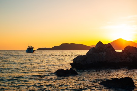 Yacht in the sea at sunset. Silhouette of a yacht on the background of the setting sun on the horizonの写真素材