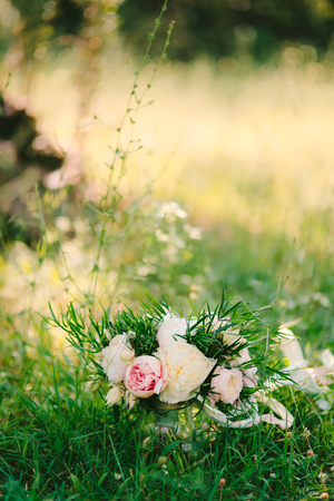 Wedding bouquet of peonies lies on the grass.の写真素材