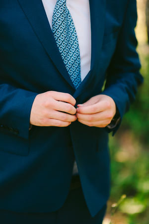The groom zips up the jacket. The wedding dress of the groom.の写真素材