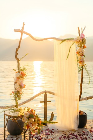 Wooden arch for the wedding ceremony at sunset. On the shore of the Bay of Kotor, Tivat, Montenegroの写真素材