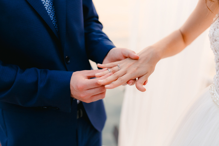 The bride puts the ring on the bridegroom at the wedding ceremony. Wedding in Montenegro.の写真素材