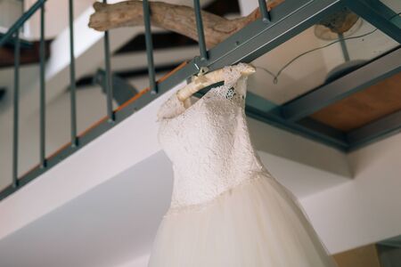 The brides dress hangs in the apartment. Bridesmaids at the wedding. Wedding in Europe.の写真素材
