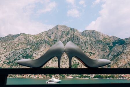 Wedding shoes of the bride on the balcony. Against the backdrop of yachts in the Bay of Kotor and mountains in Montenegro.の写真素材