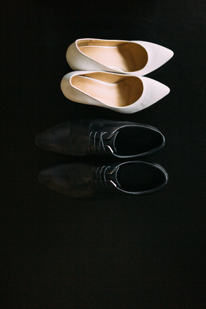 Shoes of the bride and groom. Lying or standing next to each other. Wedding accessories bride and groom.の写真素材
