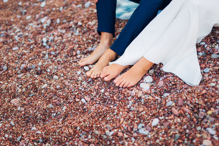 Womens and mens feet in the sand. Wedding in Montenegroの写真素材
