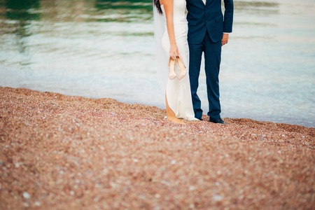 Womens and mens feet in the sand. Wedding in Montenegroの写真素材