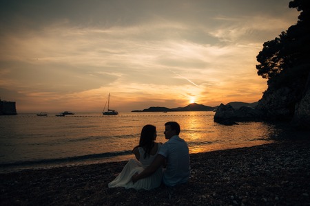 Silhouettes of couples near Sveti Stefan island in Montenegroの写真素材