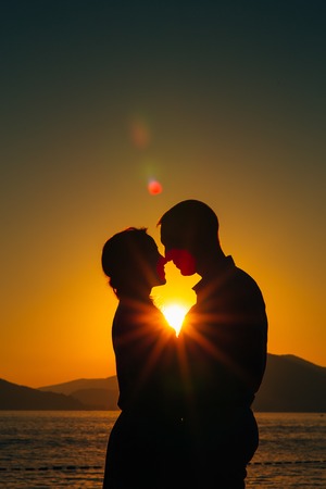 Silhouettes at sunset on the beach in Montenegroの写真素材