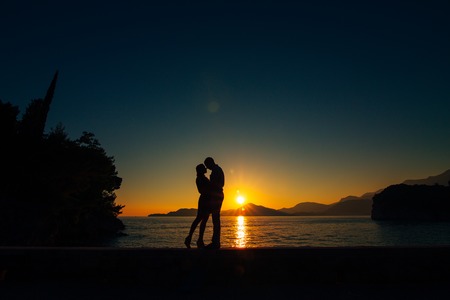 Silhouettes at sunset on the beach in Montenegroの写真素材