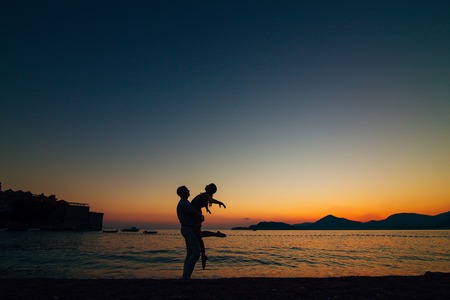 Silhouettes of couples near Sveti Stefan island in Montenegroの写真素材