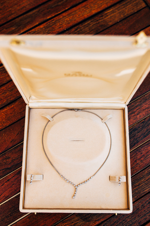 vintage accessories, powder box, scarf, necklace and handbag on wooden tableの写真素材