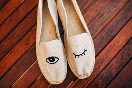 bouquet of flowers and greenery and shoes bride and groom lying on an old wooden benchの写真素材