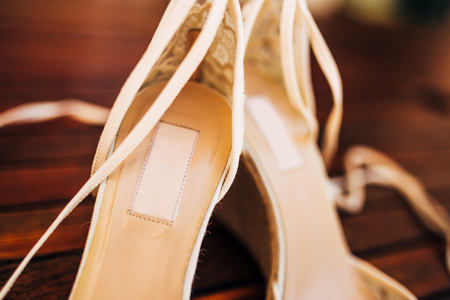 bouquet of flowers and greenery and shoes bride and groom lying on an old wooden benchの写真素材