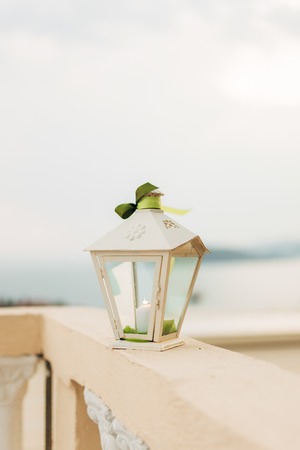 Wax candle in a white lantern. Wedding decorations.の写真素材