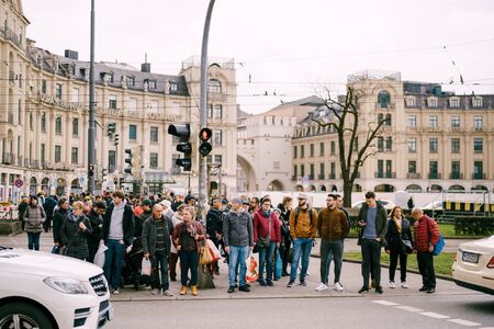 GERMANY, MUNICH - MARCH 13, 2018: A crowd of people crossing the road at the traffic lights.のeditorial素材
