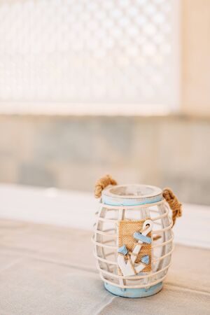 Wooden candlestick with decorative anchor on the tableの写真素材