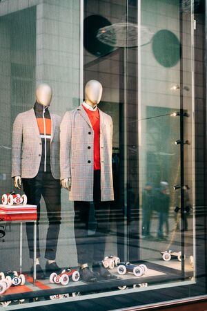 Two mannequins in the shop window of men's clothing, dressed in jackets in cage 