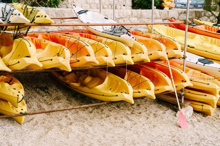 A warehouse of yellow kayaks on the shore. Single kayaks. Rental kayakshop store on sandy beachの写真素材