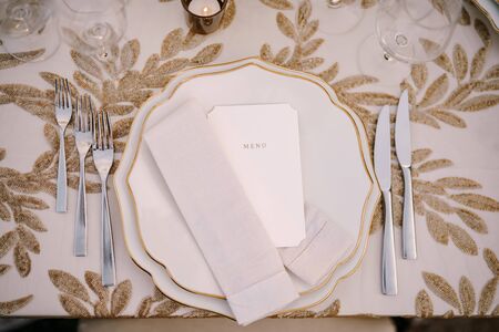 Wedding dinner table reception. Delicate creamy pastel tones of tablecloths and plates on table,...
