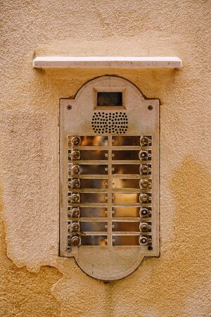 Close-ups of building facades in Venice, Italy. An old vintage intercom and a mailbox on stone wall....