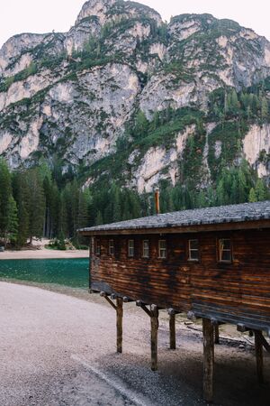 A wooden boat dock at Lago di Braies against a backdrop of rocky mountains and woodland. Braies lake in the Dolomites in South Tyrol, Italy, Briesmunicipality Municipality, in the Valley of Prague.の写真素材