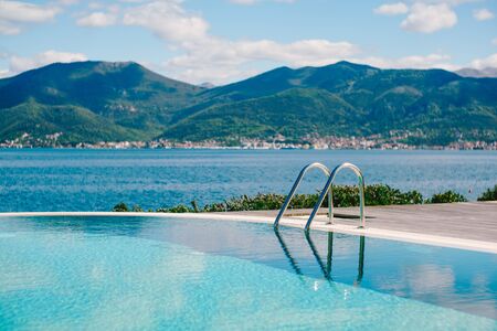 Reflecting the mountains, sea and sky in the smooth water of the pool.の写真素材