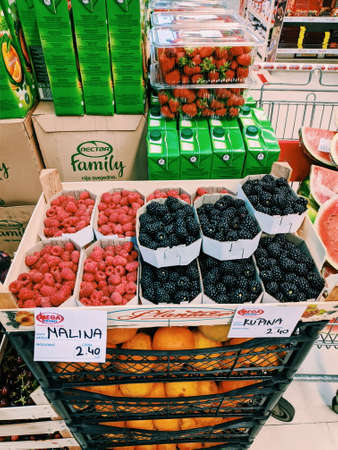 Budva, Montenegro - 10 june 2020: Boxes of raspberries and blackberries stand on boxes of oranges in...