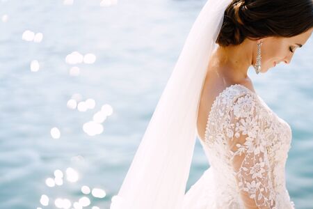 Close-up of the neck and neck of the bride, face profile. Beautiful big earring in ears, shoulder...