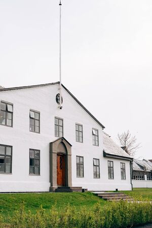 The facade of a white two-story building in Reykjavik, the capital of Iceland.