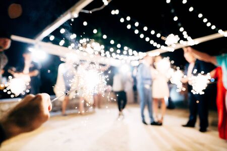A close-up of the sparkler against the backdrop of the party.の写真素材