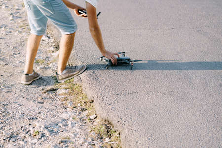 A young guy launches a drone. Preparing the quadcopter for takeoff.の写真素材