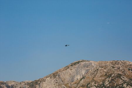 Passenger helicopter flies in the blue sky over the mountains. High quality photoの写真素材
