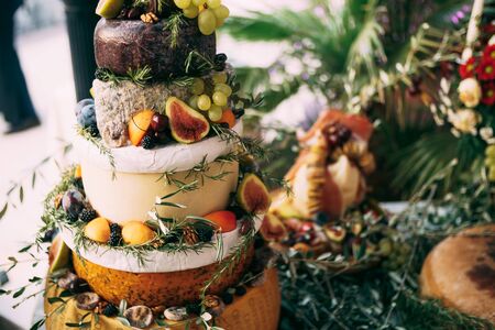 The buffet table at the festival is a makeshift cheese cake. The table is decorated with olive...