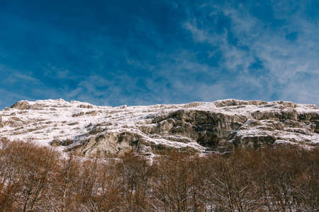 Rocky snow-covered mountain top. View from the bottom up. . High quality photoの写真素材