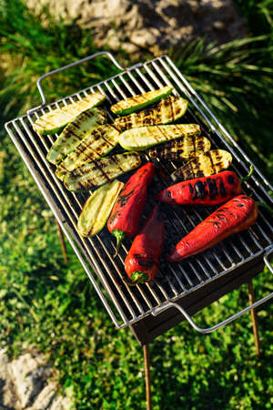Grilled vegetables on the grill outside. Sliced zucchini and paprika.