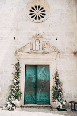 The doors to the church are green with patterns, decorated with flowers and divine symbols. Island Gospa od Skrpella in Perast, Montenegro.の写真素材
