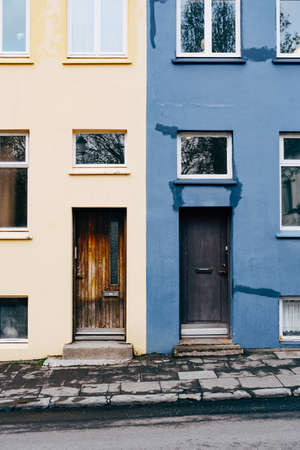 A two-color building made of blue and beige flowers with rectangular doors and asymmetric windows.の写真素材