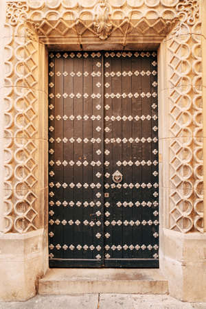 Brown doors with rivets in the arch with original molding.の写真素材