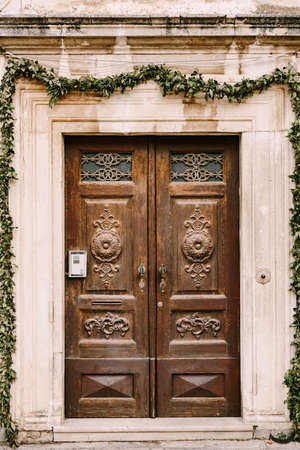 Wooden brown doors with carved elements and patterns.の写真素材