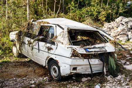Zabljak, Montenegro - 23 july 2020: Flood damaged car. A dented white passenger car, broken windows, branches and seaweed in the cabin.のeditorial素材
