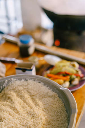 Close-up of rice for pilaf in a bowl, against the kitchen table.の写真素材
