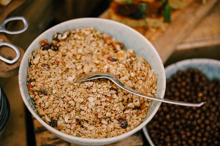 Close-up of a plate of oatmeal with dried fruit on a table with a breakfast cereal balls with cocoa.の写真素材