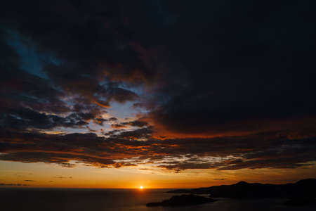 Fiery golden sunset in Montenegro over the sea. Near Sveti Stefan and the island of St. Nicholas, on...