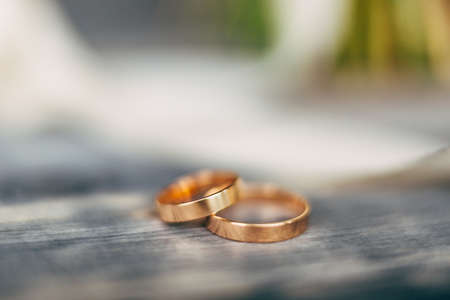 Close-up of natural gold wedding rings on a gray background.の写真素材